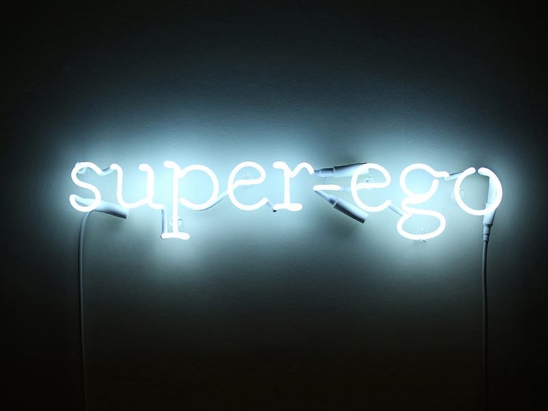 Photograph of a Gavin Turk piece = a light installation which reads 'super ego'
