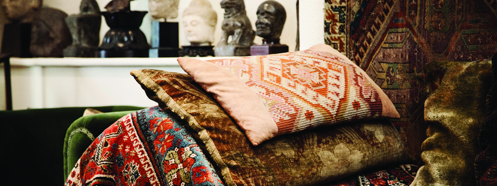 A photograph of Freud's couch which is covered in a colourful rug and cushions