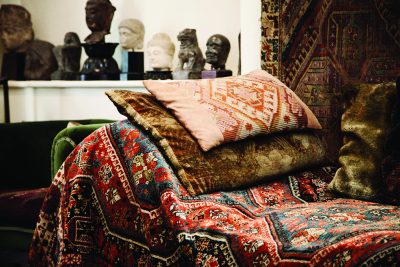 A photograph of Freud's couch which is covered in a colourful rug and cushions