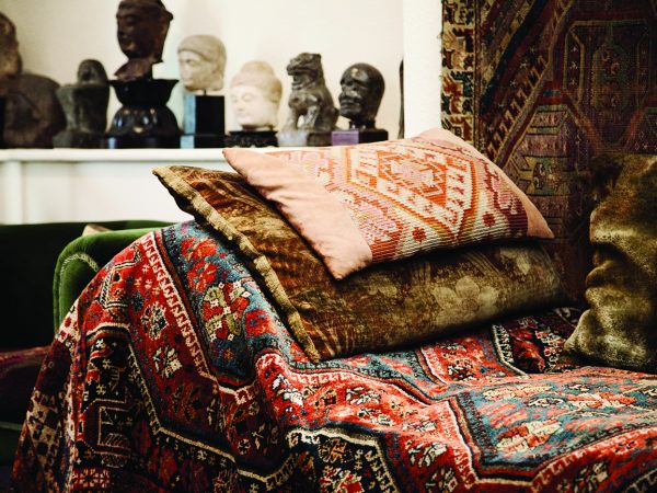 A photograph of Freud's couch which is covered in a colourful rug and cushions