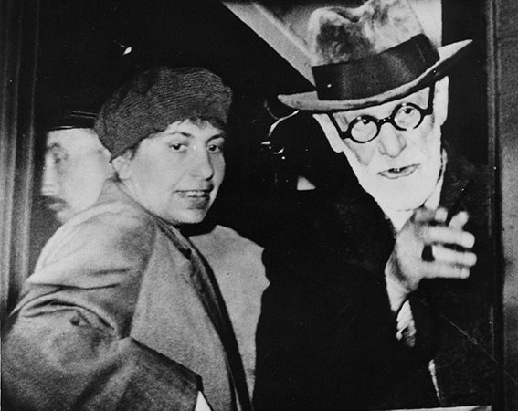 Black and white photograph of Anna and Sigmund Freud looking out of a train window.