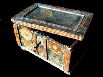 Photograph of a small painted wooden box with a loose lid and key in keyhold