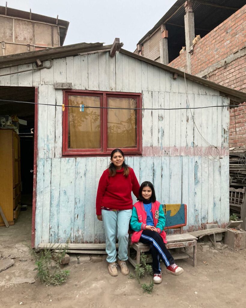 Lizet outside her house with Lima, her daughter